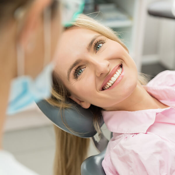Woman is happily smiling in a dental chair