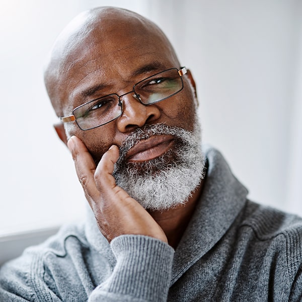 Middle-aged man in glasses thinking