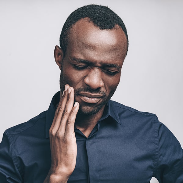 Man in pain holding his hand near his face