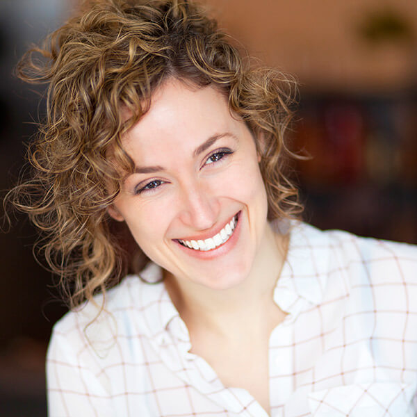 A middle-aged woman is happily smiling with her White Dental Fillings
