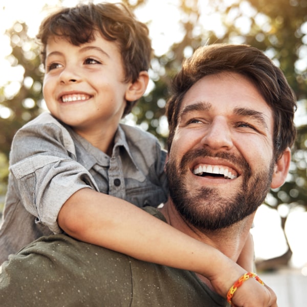 Father and son hug and smile.